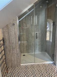 a shower with a glass door in a bathroom at Grainbank Mews in Kirkwall