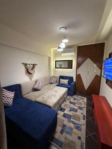 ein Wohnzimmer mit einem Sofa und einem TV in der Unterkunft Porto El Sokhna Aqua park in Ain Suchna