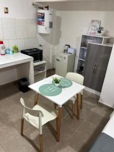 - une petite cuisine avec une table et des chaises dans la chambre dans l'établissement Hospedaje LH C A15minutos del aeropuerto ezeiza, à Ezeiza