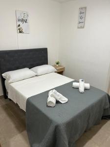 - une chambre avec un lit et des serviettes dans l'établissement Hospedaje LH C A15minutos del aeropuerto ezeiza, à Ezeiza