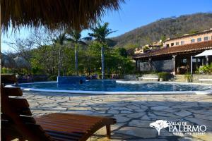 a large swimming pool with a bench in front of a building at Villas de Palermo Hotel and Resort in San Juan del Sur