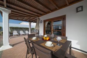 uma mesa de jantar no pátio de uma casa em Sophisticated Lanzarote Villa | Villa Mervella | 4 Bedrooms | Spacious Terrace Area & Private Pool | Playa Blanca em Playa Blanca