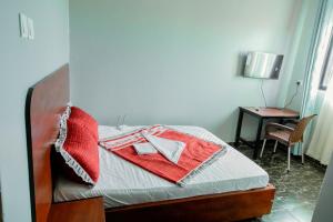 a bedroom with a bed with red towels on it at the transit haven in Kampala