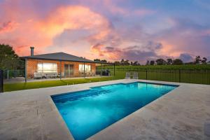 a swimming pool in a yard with a house at The Lodge - Ironstone Estate Hunter Valley in Lovedale