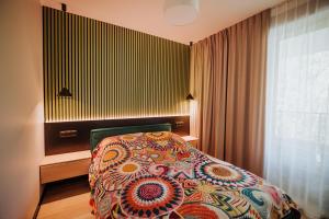 a bedroom with a bed with a colorful bedspread at Pod Twisterem in Bielsko-Biała