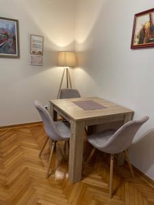 a wooden table with two chairs and a lamp at Cozy Trg in Lazarevac