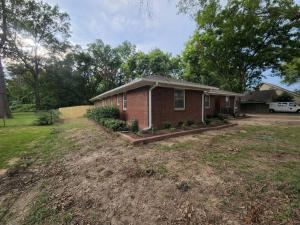 una pequeña casa de ladrillo en medio de un patio en Sits on an acre near Grace land with 3 full baths en Memphis