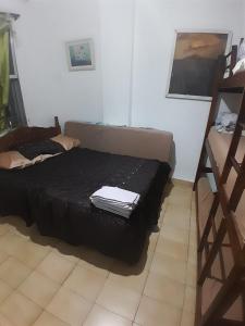 a bedroom with a bed with a black bedspread at frente ao mar in São Vicente +20 photos