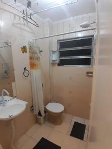 La salle de bains est pourvue de toilettes et d'un lavabo. dans l'établissement frente ao mar, à São Vicente
