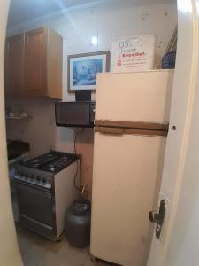 a small kitchen with a stove and a refrigerator at frente ao mar in São Vicente