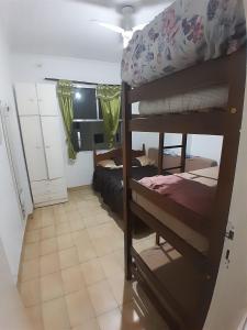 a room with two bunk beds and a desk at frente ao mar in São Vicente