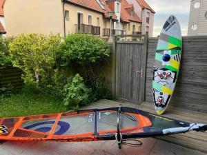 a kayak is parked next to a surfboard at Le Repère des Surfeurs in Wissant +2 photos