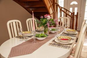 uma mesa de jantar com pratos e flores em Villa Martini em Vátos