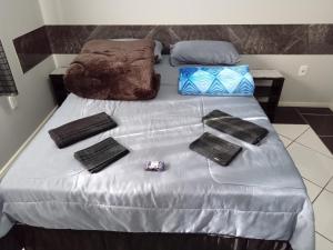 łóżko z ręcznikami i torbami na górze w obiekcie POUSADA ALTERNATIVA MANU LAGES suite w mieście Lages