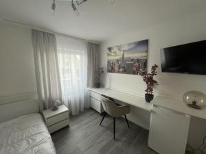 Habitación blanca con escritorio, 1 cama y 1 dormitorio en Einzelzimmer mit privatem Bad nähe Ulmer Donautal - ideal für Geschäftsreisen en Ulm
