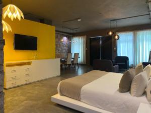 een slaapkamer met een groot bed en een gele muur bij Ilo Rojo Hotel Boutique in San Miguel de Allende