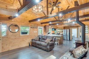a living room with a couch and a kitchen at Cozy Hemphill Cabin with Lake Views and Deck! in Hemphill