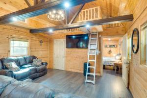 a living room with a couch and a ladder at Cozy Hemphill Cabin with Lake Views and Deck! in Hemphill