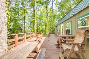 a deck with wooden benches and tables on a house at Cozy Hemphill Cabin with Lake Views and Deck! in Hemphill