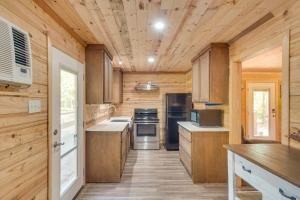 een keuken met houten wanden en houten vloeren bij Quiet Hemphill Cabin Retreat Near Toledo Bend Lake in Hemphill