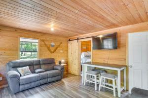 een woonkamer met een bank en een tafel bij Quiet Hemphill Cabin Retreat Near Toledo Bend Lake in Hemphill