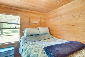 een slaapkamer met een bed in een houten hut bij Quiet Hemphill Cabin Retreat Near Toledo Bend Lake in Hemphill