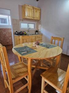 a kitchen with a wooden table with chairs and a tableablish at Encantador depto cerca Terminal in Posadas