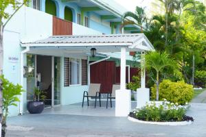 a patio of a house with a table and chairs at Vedanta Resort Barbados in Bridgetown