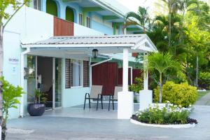 un patio de una casa con mesa y sillas en Palm Garden Hotel Barbados, en Bridgetown