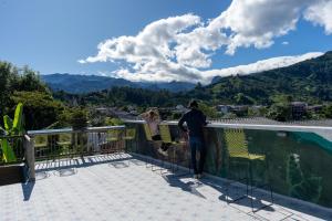un hombre de pie en un balcón con vistas a las montañas en Terasu Hotel Boutique Salento, en Salento 74 fotos más