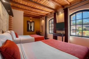 a hotel room with two beds and a window at Sonesta Posadas del Inca - Valle Sagrado Yucay Urubamba in Urubamba