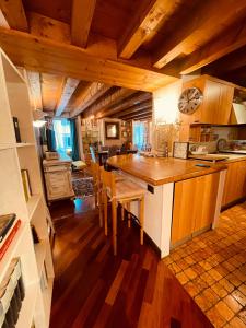 een keuken met houten plafonds en een groot eiland met stoelen bij Piccolo Mondo Antico in Verona