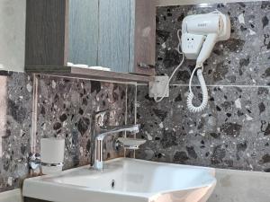 a bathroom with a sink and a hair dryer at Ramez luxury camp in Disah