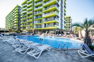 a swimming pool with lounge chairs and a building at Azur 148 - Pool & Spa Beach Resort in Mamaia