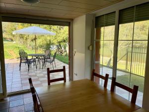 a dining room with a table and chairs and an umbrella at 069 Riverside Vikendica - Banja Luka in Rekavice