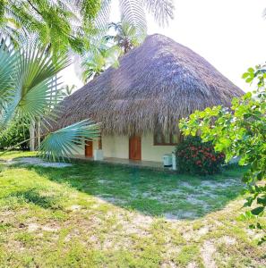 Cette petite maison dispose d'un toit de chaume et d'une cour. dans l'établissement Sierra Sagrada Tayrona, à Guachaca