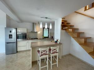 a kitchen with a counter with two chairs and a staircase at Apartment Lucille in Kali