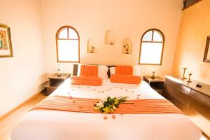 a bedroom with a large bed with two windows at Chalet Campestre la Peseta in Ubaté