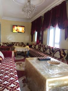 ein Wohnzimmer mit einem Sofa und einem Kronleuchter in der Unterkunft old city apartment + free couscous on Friday in Tangier