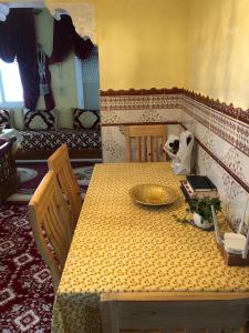 einem gelben Tisch mit einer Platte darüber in der Unterkunft old city apartment + free couscous on Friday in Tangier