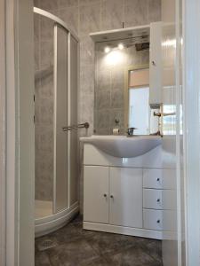 a white bathroom with a sink and a mirror at House Pool in Ičići