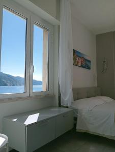 a white bedroom with a bed and a window at La Casa sul Mare - Monterosso - Cinque Terre in Monterosso al Mare