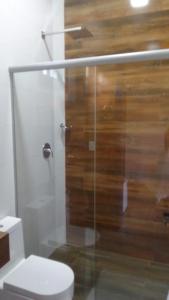 a bathroom with a glass shower with a toilet at Pousada Usina Paraíso in Astolfo Dutra