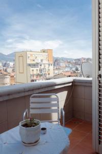 a table and chair on a balcony with a view at ALBJONA GUESTHOUSE TIRANA in Tirana