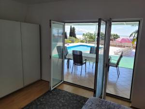 a room with glass doors and a table and a pool at House Pool in Ičići