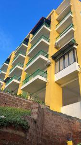 a yellow and white apartment building with balconies at The Nautical Nest - Para House in Canacona