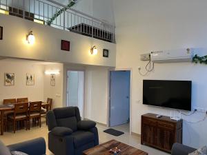The Nautical Nest - Para House في محطة كاناكونا: غرفة معيشة مع تلفزيون وغرفة طعام