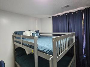 a bedroom with two bunk beds with blue curtains at Cozy Bartlett home with garage, fenced backyard in Memphis