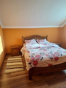 1 Schlafzimmer mit einem Bett mit Blumenbettdecke in der Unterkunft Cabana din șes in Mărişel