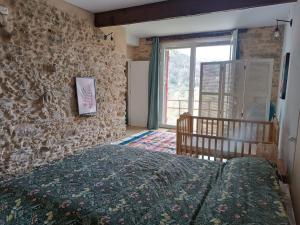 una camera da letto con un letto e un muro di pietra di O Salgueiral a Castro Caldelas